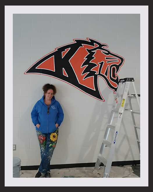 Artist standing by wall mural